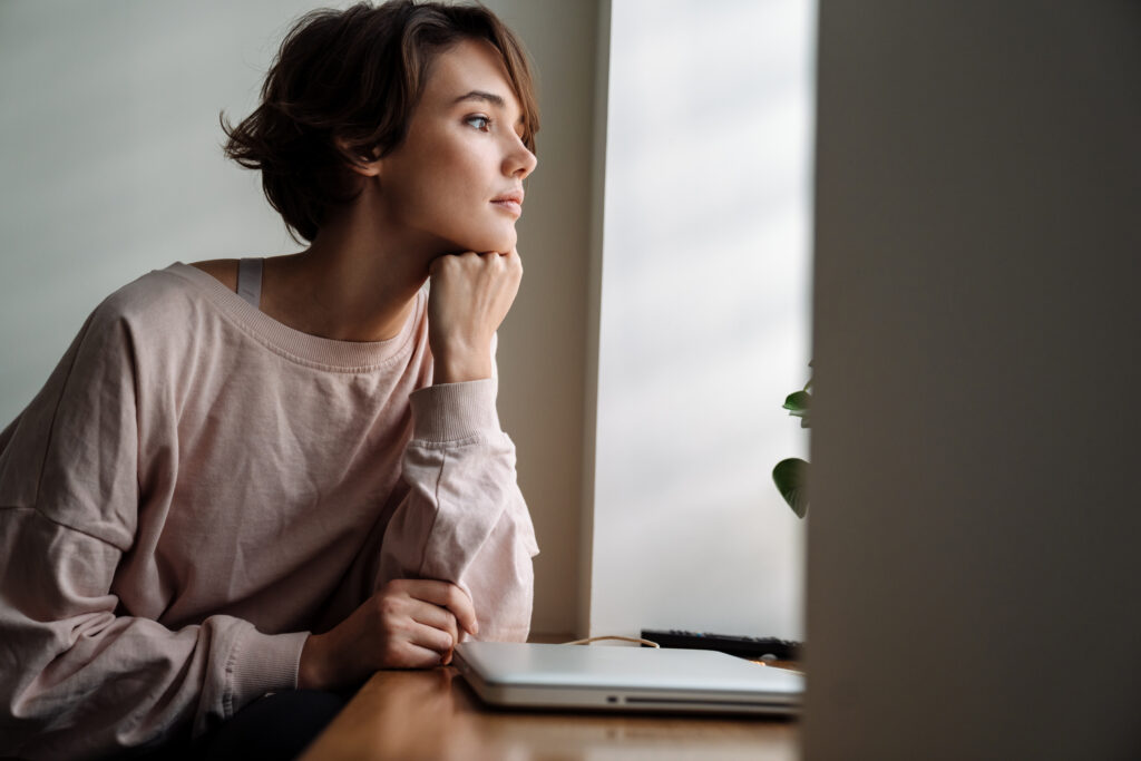 young woman looking out the window with possible anxiety disorder