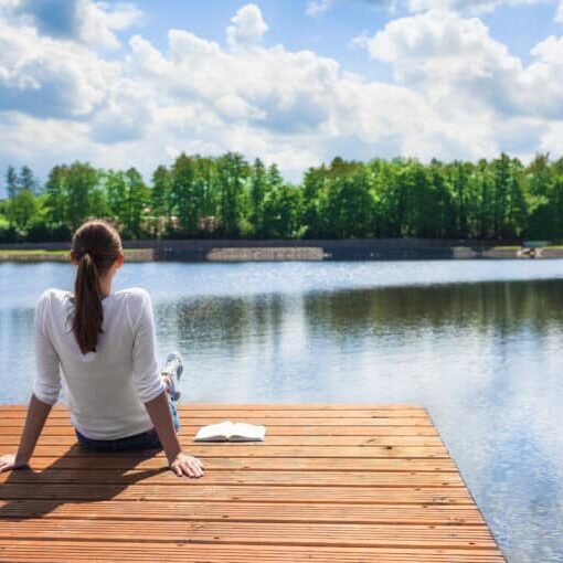 woman relaxing by a lake after experiencing panic attack symptoms