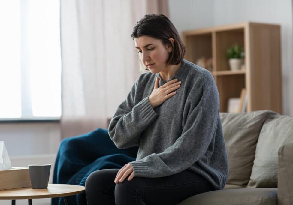 panic attack vs. heart attack - woman having trouble breathing or panic attack at home