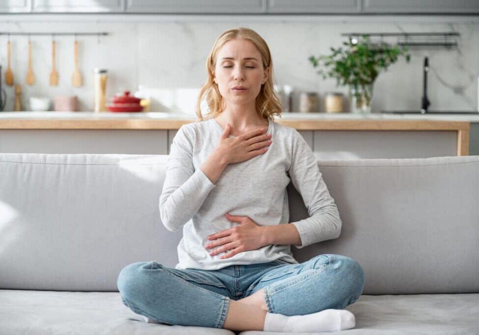 advanced breathing techniques to stop a panic attack - Woman doing calming breathing exercises after panic attack