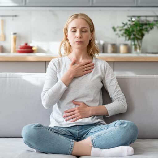 advanced breathing techniques to stop a panic attack - Woman doing calming breathing exercises after panic attack