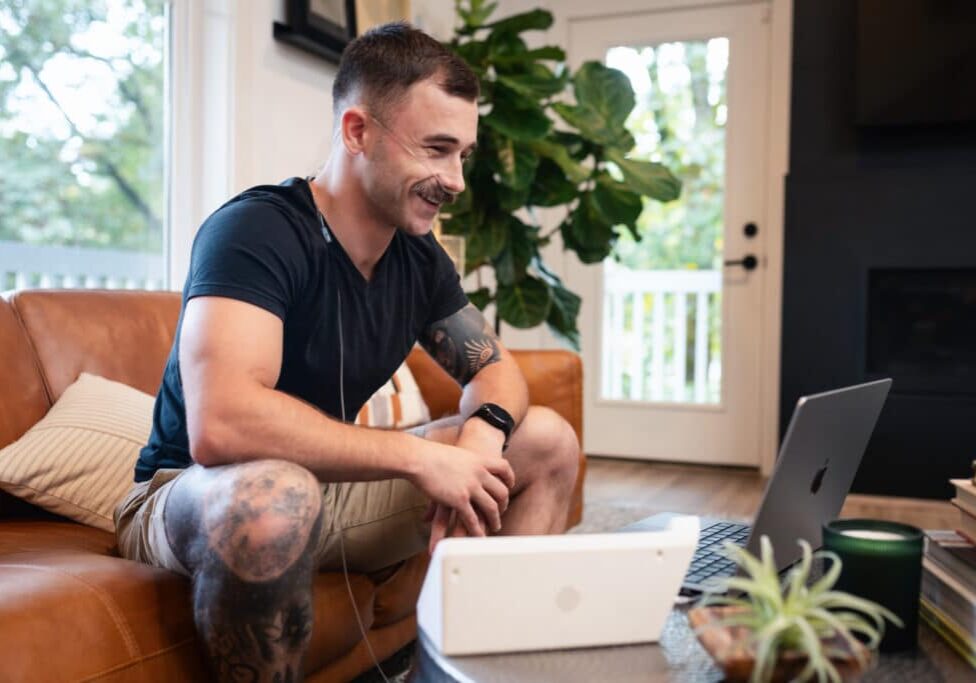 Young man using the Freespira treatment in his living room