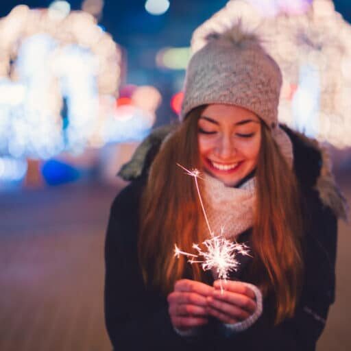Happy woman at New Year's eve holding burning sparkler