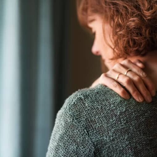 Rear view shot of a woman suffering from a shoulder pain