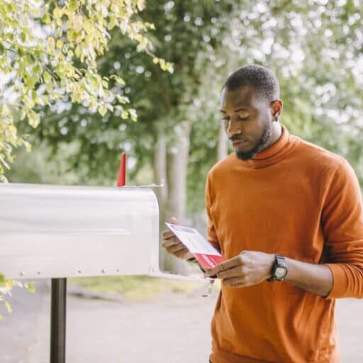 Portrait of African-American man receiving mail-in voting ballot.