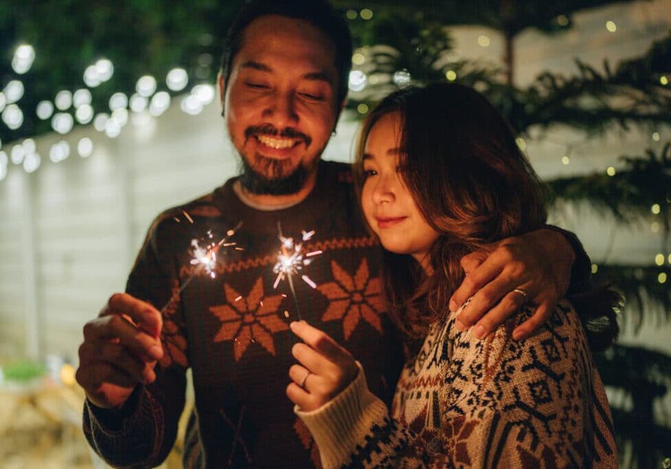 Asian friends Celebrating New Year Party with Sparkler in front yard home