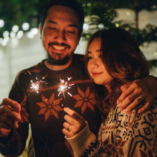 Asian friends Celebrating New Year Party with Sparkler in front yard home
