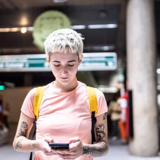 Young woman using the mobile phone in the subway station