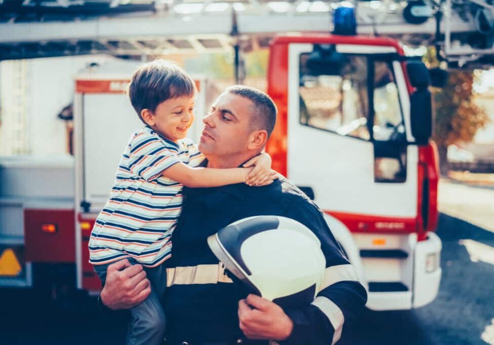 Firefighter with smiling boy after successful rescue operation