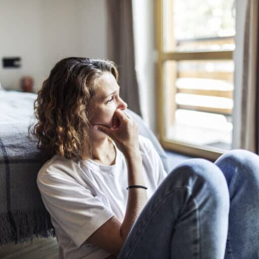 Young adult woman sitting at home alone