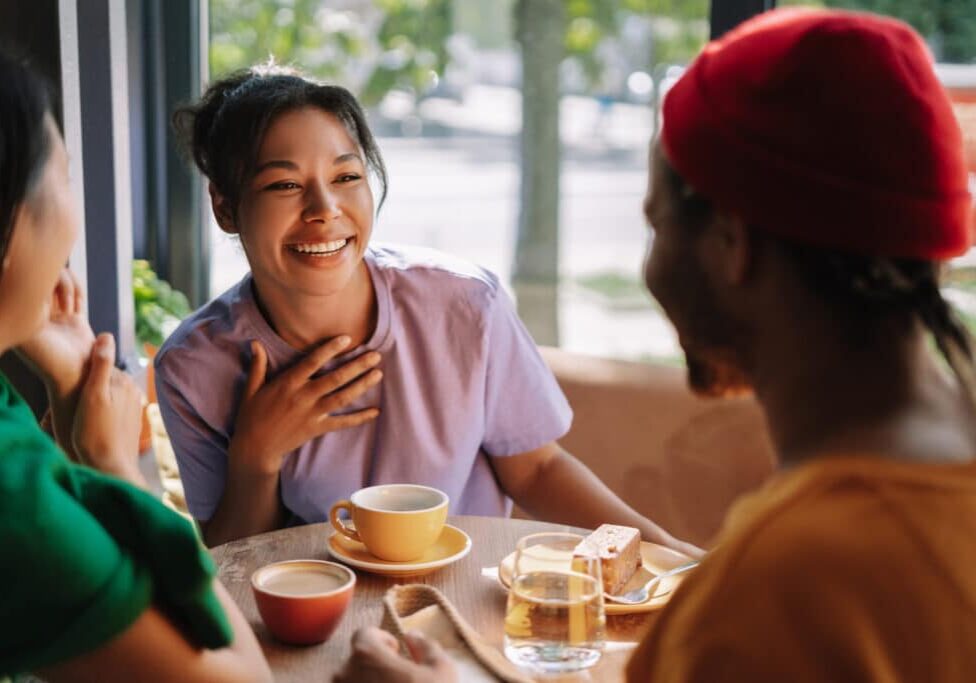 Diverse group of friends enjoying coffee and cake in a bustling cafe