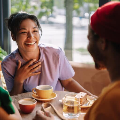 Diverse group of friends enjoying coffee and cake in a bustling cafe