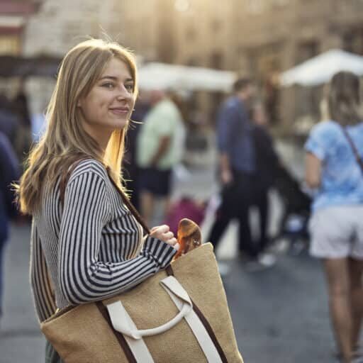 Happy teenager girl walking in a crowd of market day