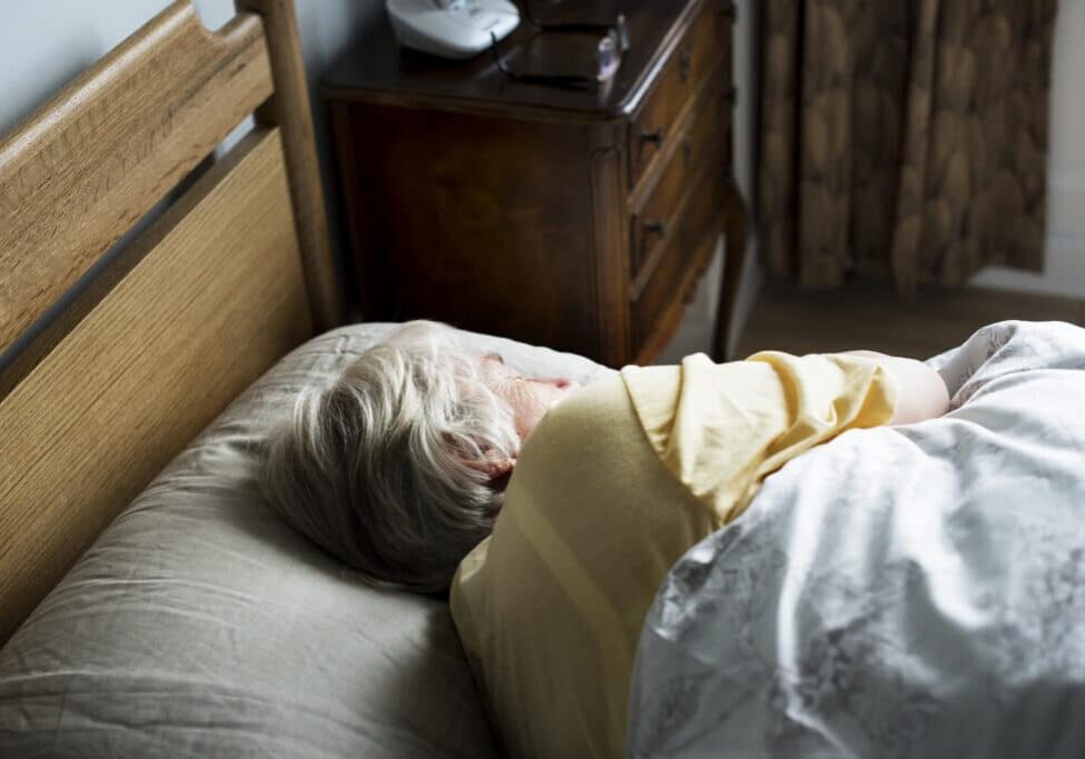 Elderly caucasian woman sleeping on the bed