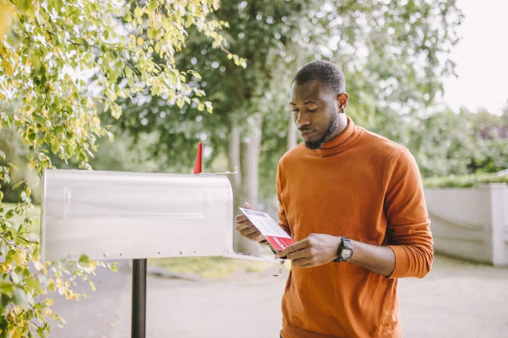 Portrait of African-American man receiving mail-in voting ballot.