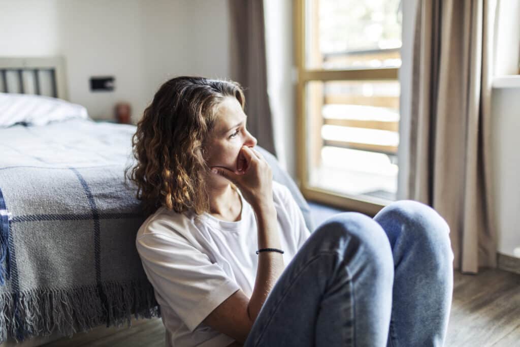 Young adult woman sitting at home alone