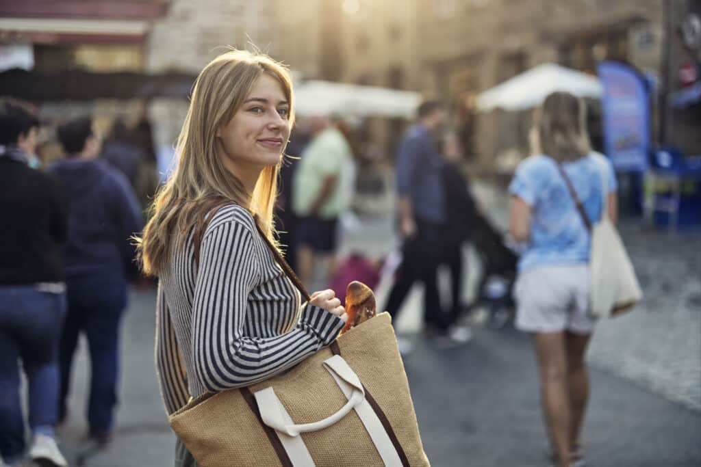 Happy teenager girl walking in a crowd of market day