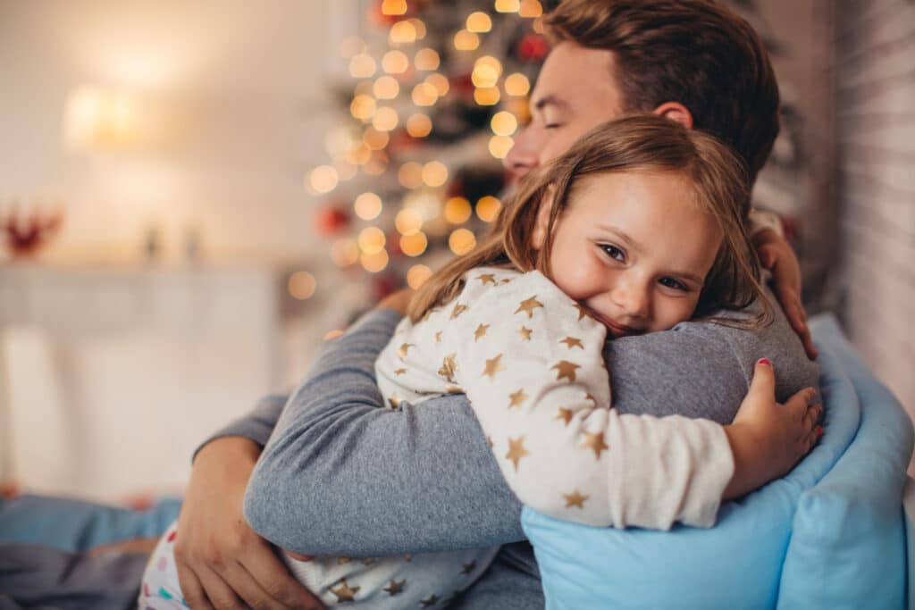 Father and his cute daughter in front of christmas three